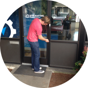 Picture of SiteCrafting designer, Glen, opening front door of seattle office