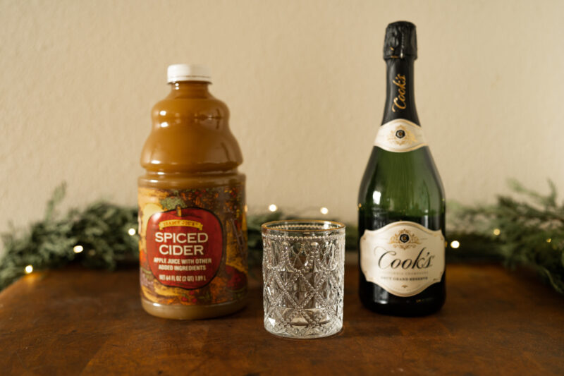 Ingredients for apple cider mimosa: champagne, apple cider and glass