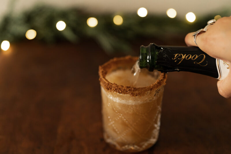 Champagne being poured into glass with apple cider
