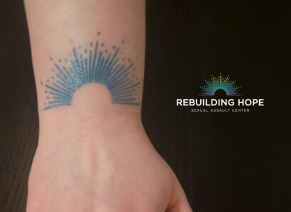 a wrist with the rebuilding hope logo tattoo on it.