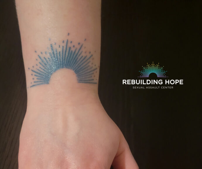 a wrist with the rebuilding hope logo tattoo on it.