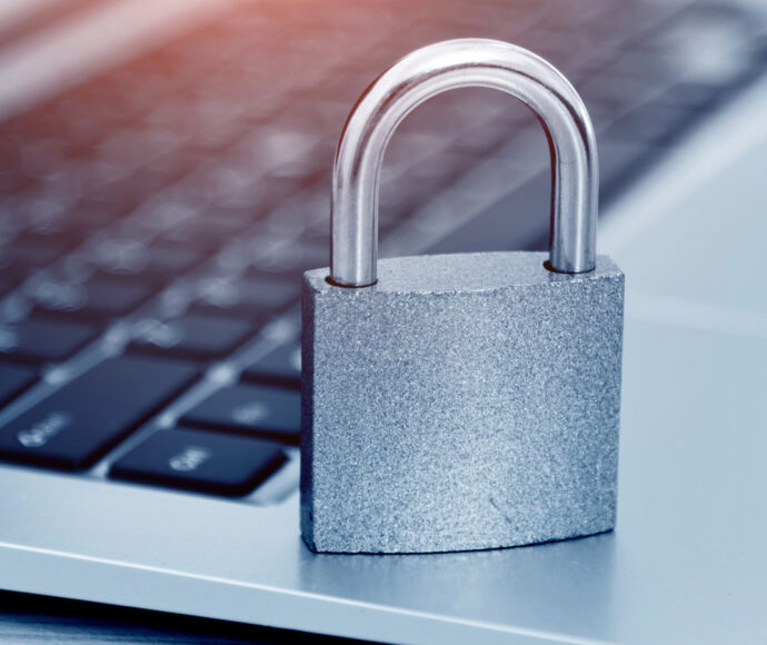 Padlock sitting on a laptop keyboard.