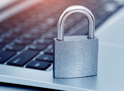 Padlock sitting on a laptop keyboard.