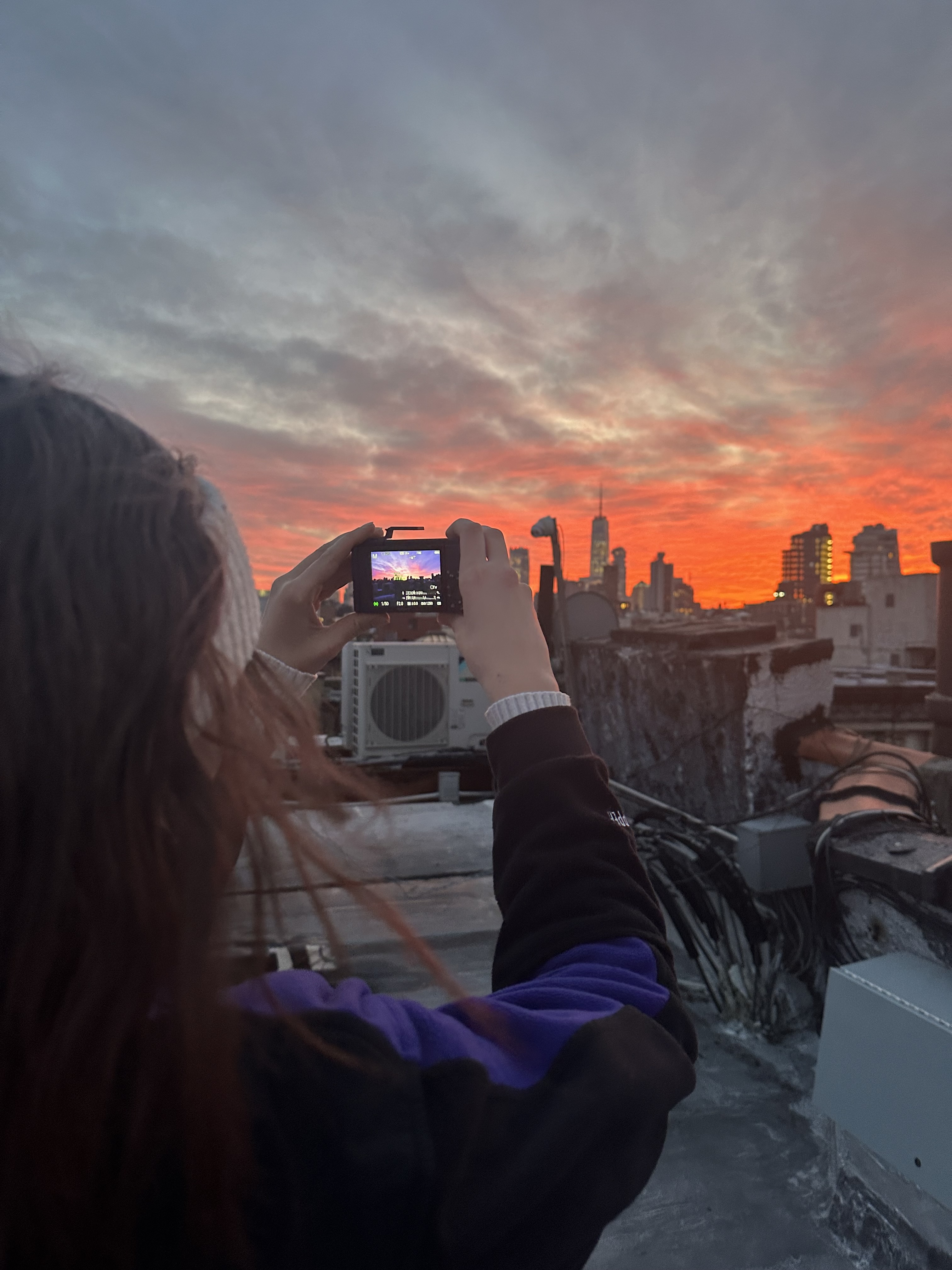 Employee Charlotte taking a photo of the sunset on a digital camera