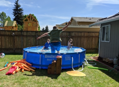 Mark Neidlinger jumping into a swimming pool with his kids.