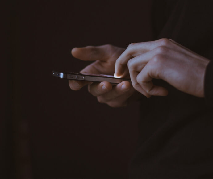 Hands interacting with a mobile phone.