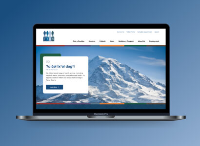 Laptop displaying the Puyallup Tribal Health Authority website's home page, which features a snowy mountain landscape and the Lushootseed phrase for 