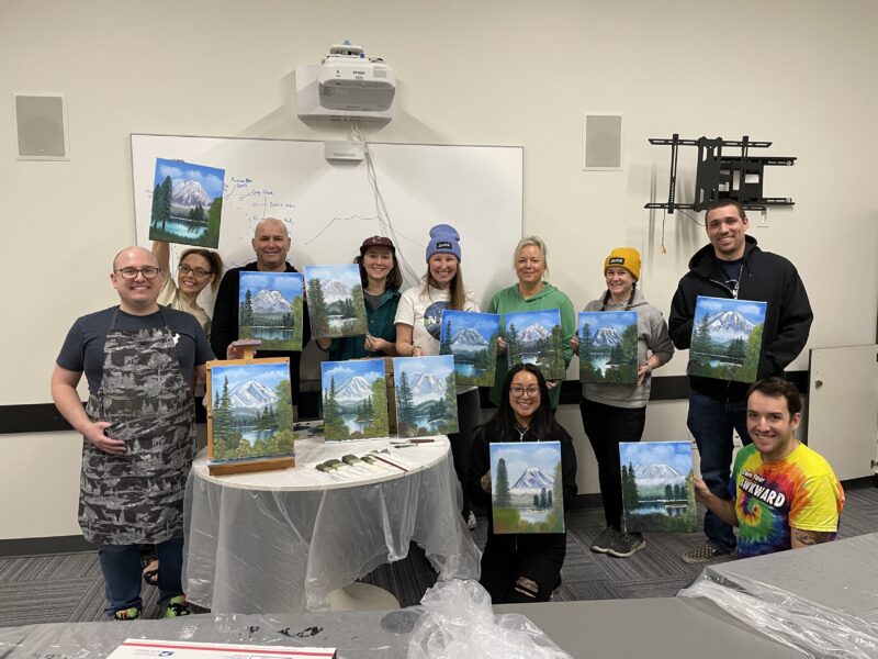 Group photo of employees with finished paintings