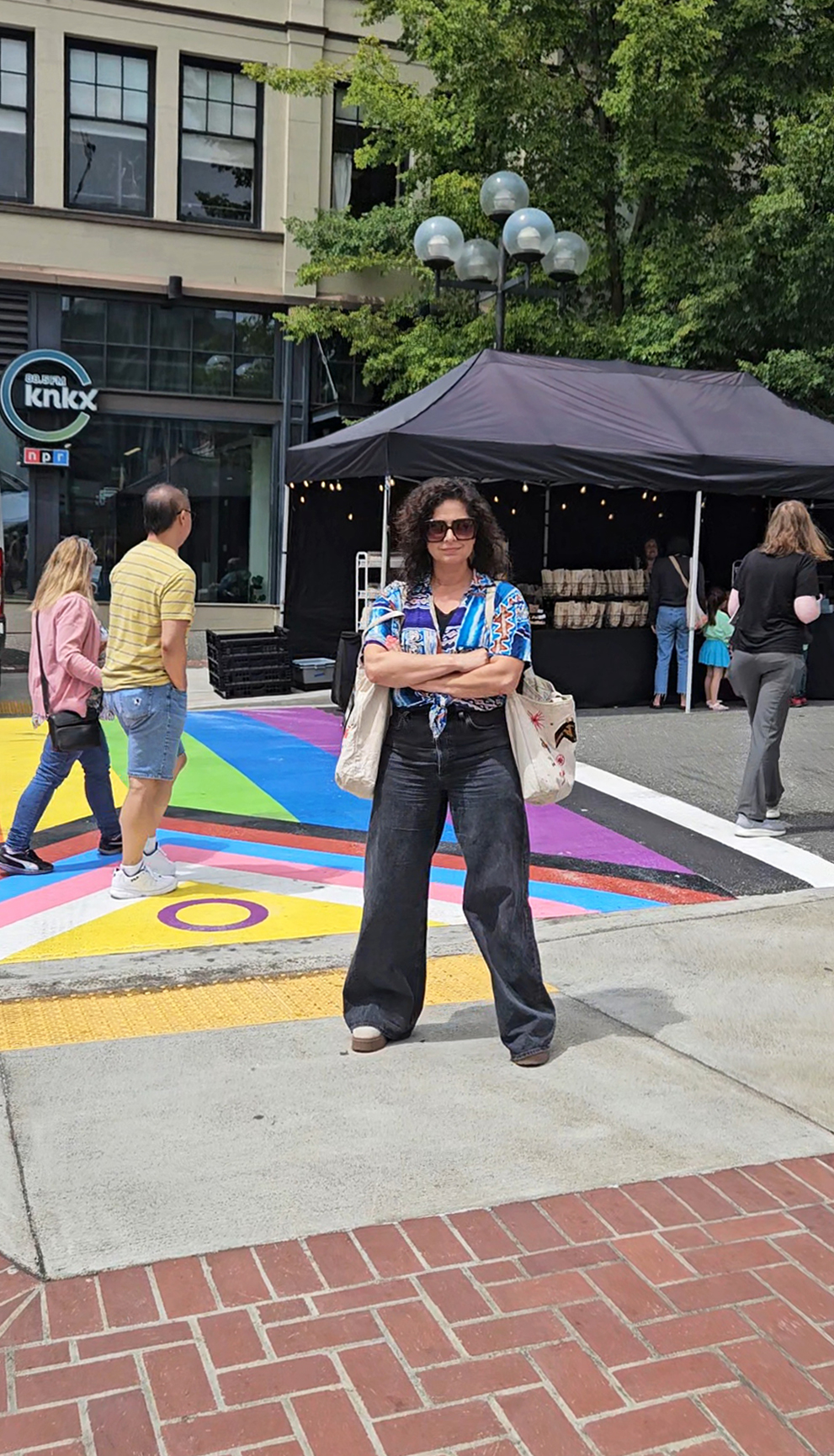 Jen poses in front of the Intersex-Inclusive Progress Pride Flag painted on the street.