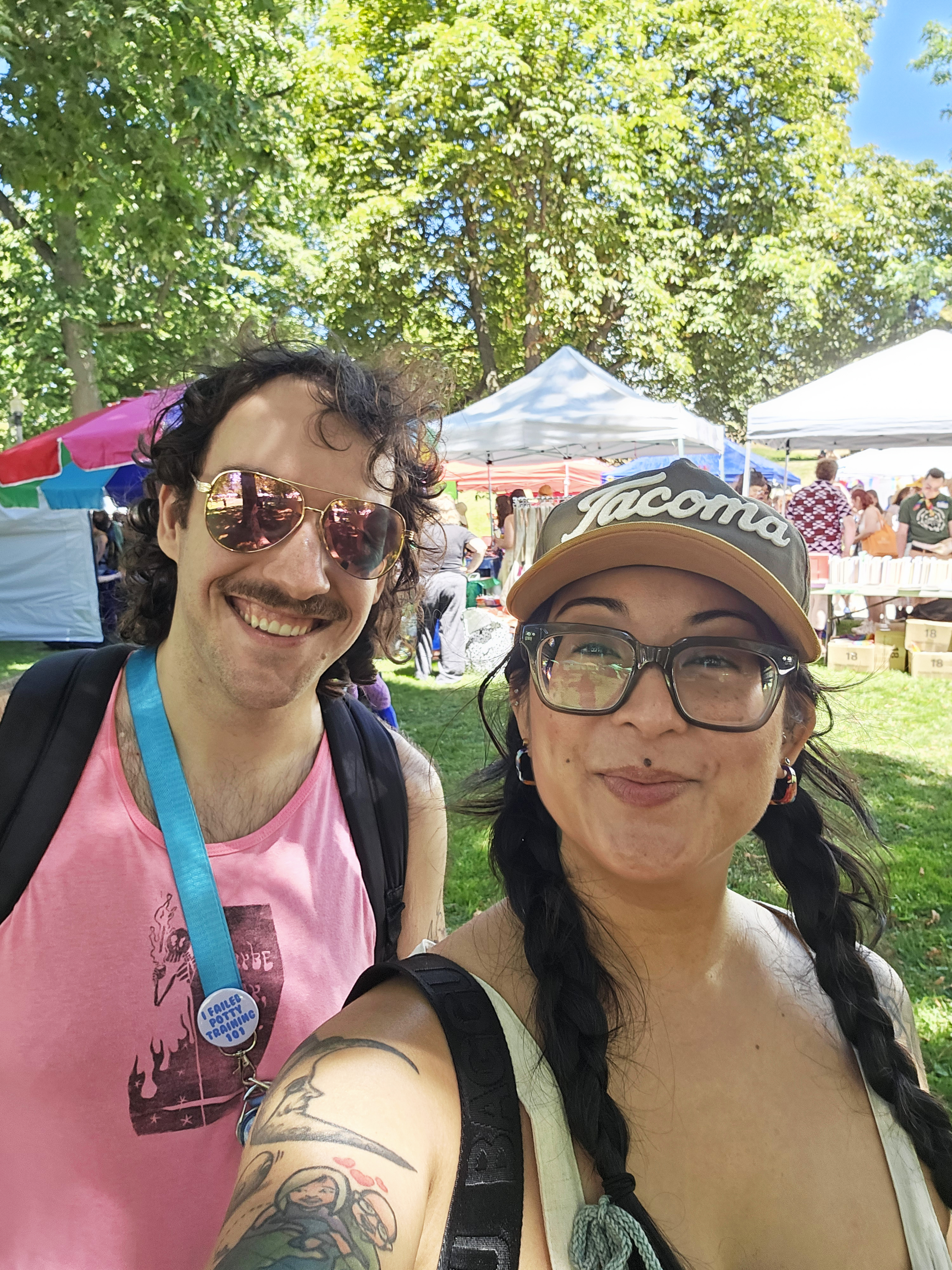 Alex and Tiffany smiling at Pride Festival in the park