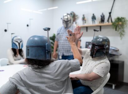 SiteCrafting employees wearing StarWars helmets and high-fiveing.