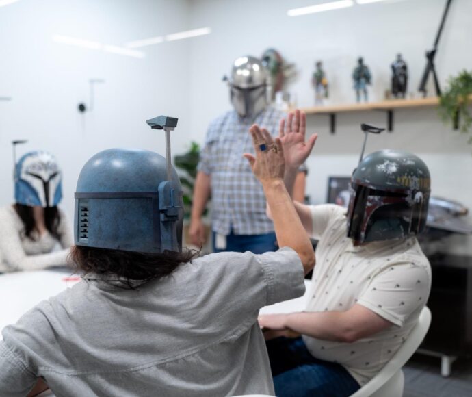SiteCrafting employees wearing StarWars helmets and high-fiveing.