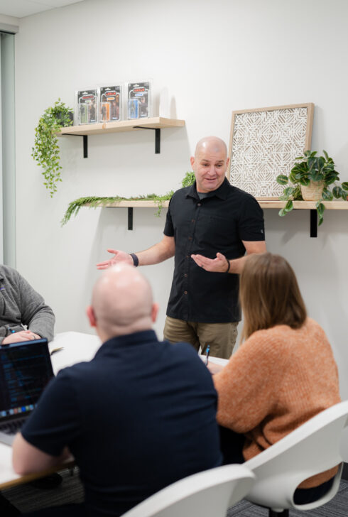 SiteCrafting's president Brian Forth talking to employees in a conference room.