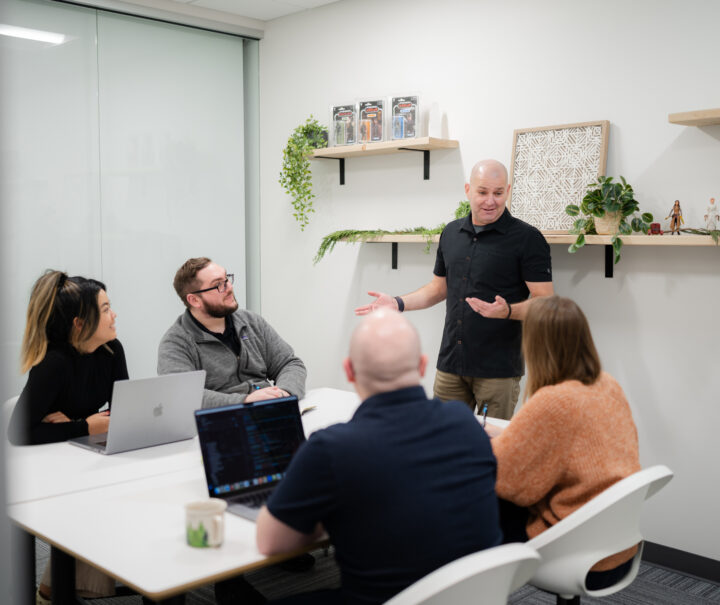 SiteCrafting's president Brian Forth talking to employees in a conference room.