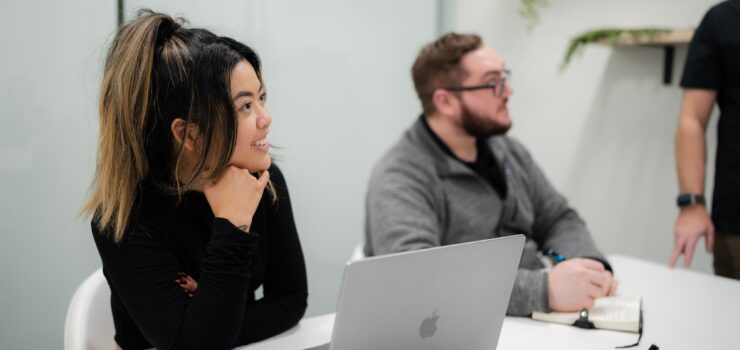 Woman and man in conference room laughing.