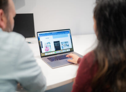 Two SiteCrafting employees reviewing a user experience goal setting workshop presentation