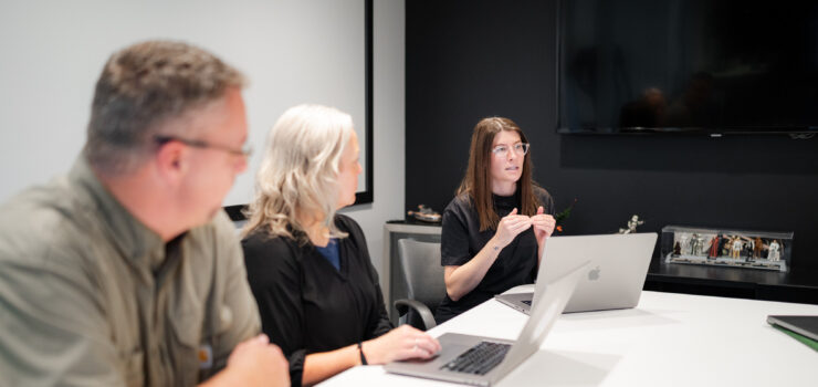 Three project manages talking about consulting.