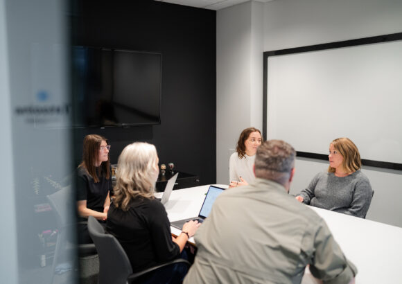 Project managers sitting around a conference room table.