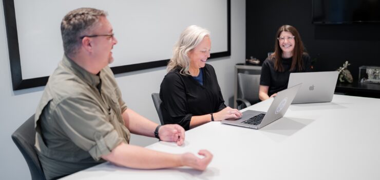 Project managers around a table discussing big ideas.
