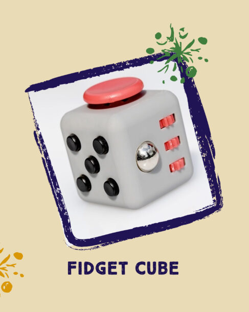 A light grey cube with a silver ball, six black buttons, three red cogwheels and a large red circle. The fidget cube is against a light background in a blue border with one artistic snowflake overlayed.
