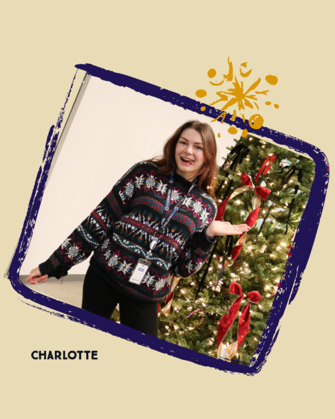 SiteCrafting employee Charlotte wearing a holiday pattern knit sweater posing with her tongue sticking out.