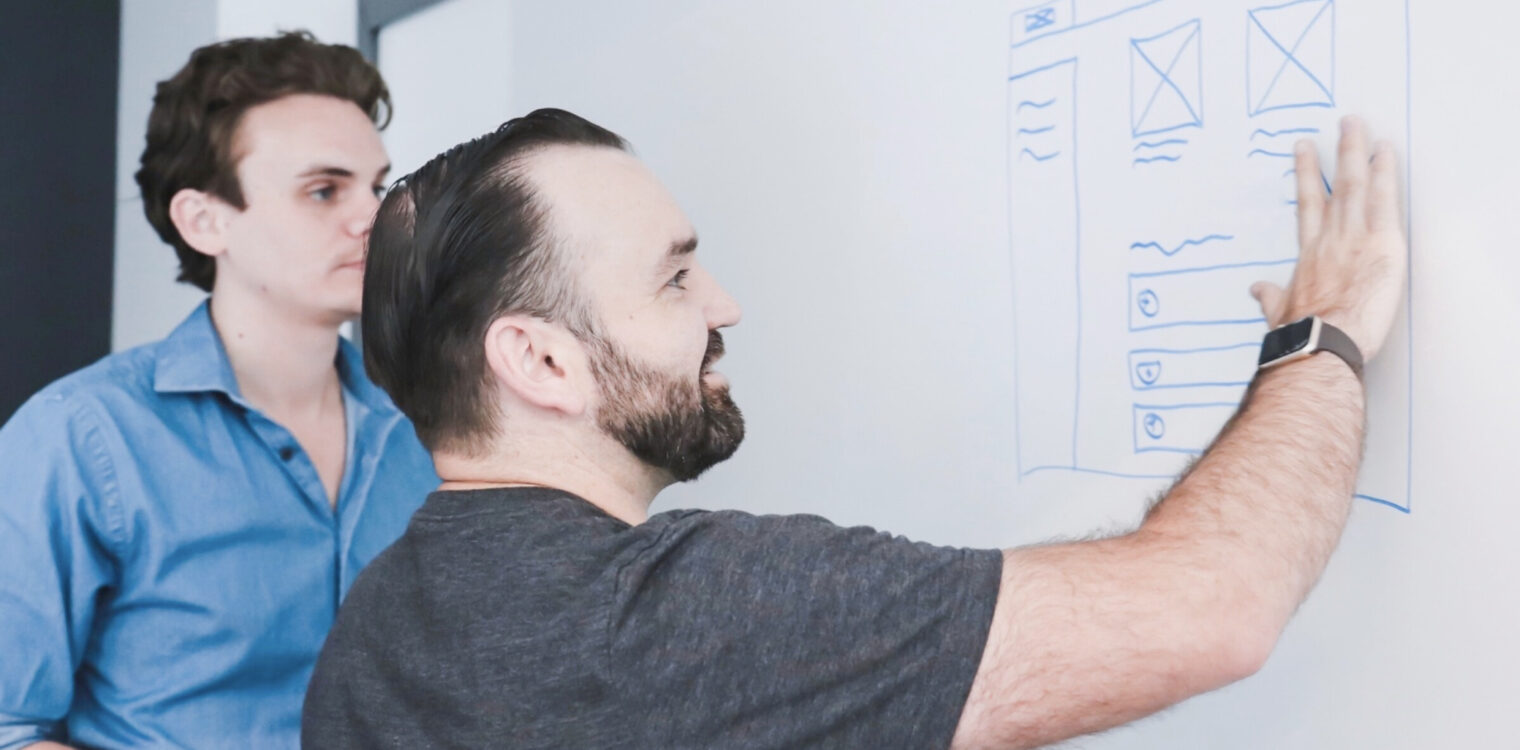 Nick Colvin and Chuck Johnston mapping out web content patterns on a white board.