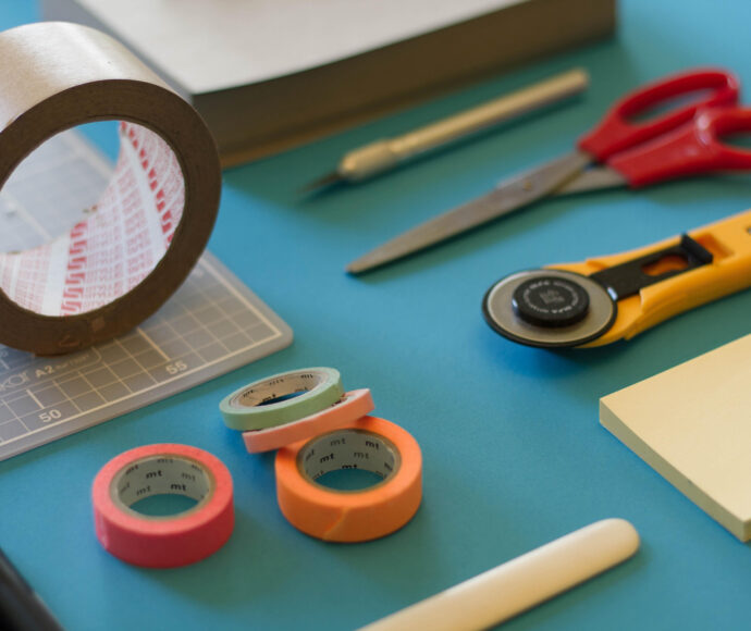 Various tools, tape and paper on a desk.