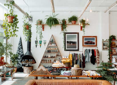 Trendy shop full of clothes, greenery, and products.