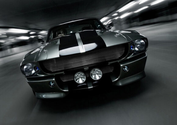 The front of a Ford mustang driving fast