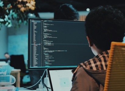 Developer writing code on a laptop at a desk.
