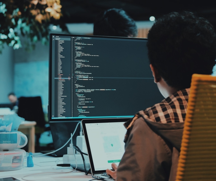 Developer writing code on a laptop at a desk.