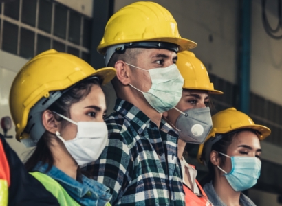 Group of people wearing hard hats and masks.