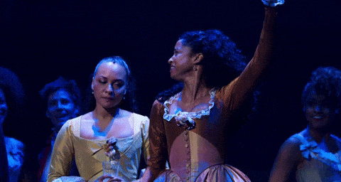 Animated gif of two Hamilton musical cast members hugging and singing.