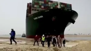 Gif of people walking in front of the Ever Given ship