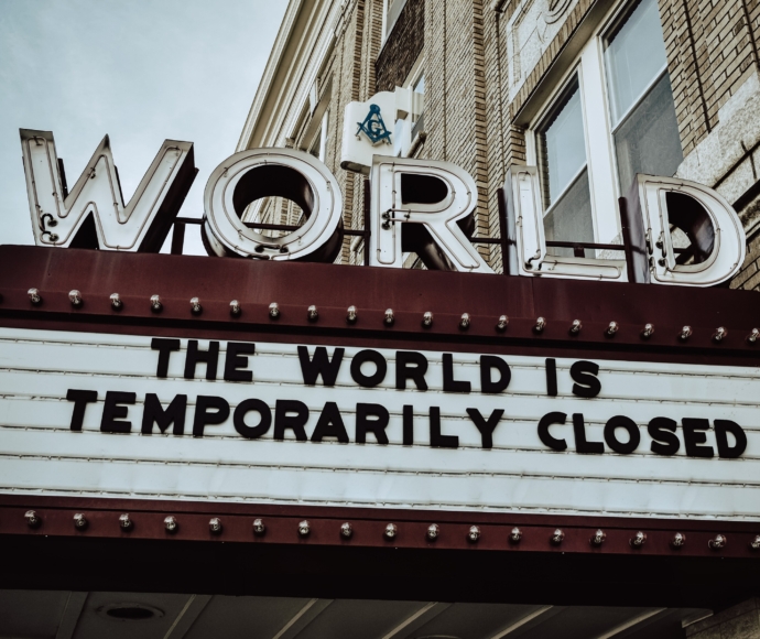Marquee sign that reads the world is temporarily closed