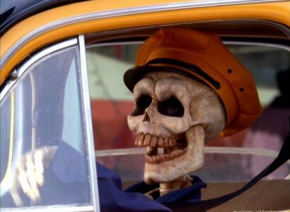 A skeleton driving a taxi cab.