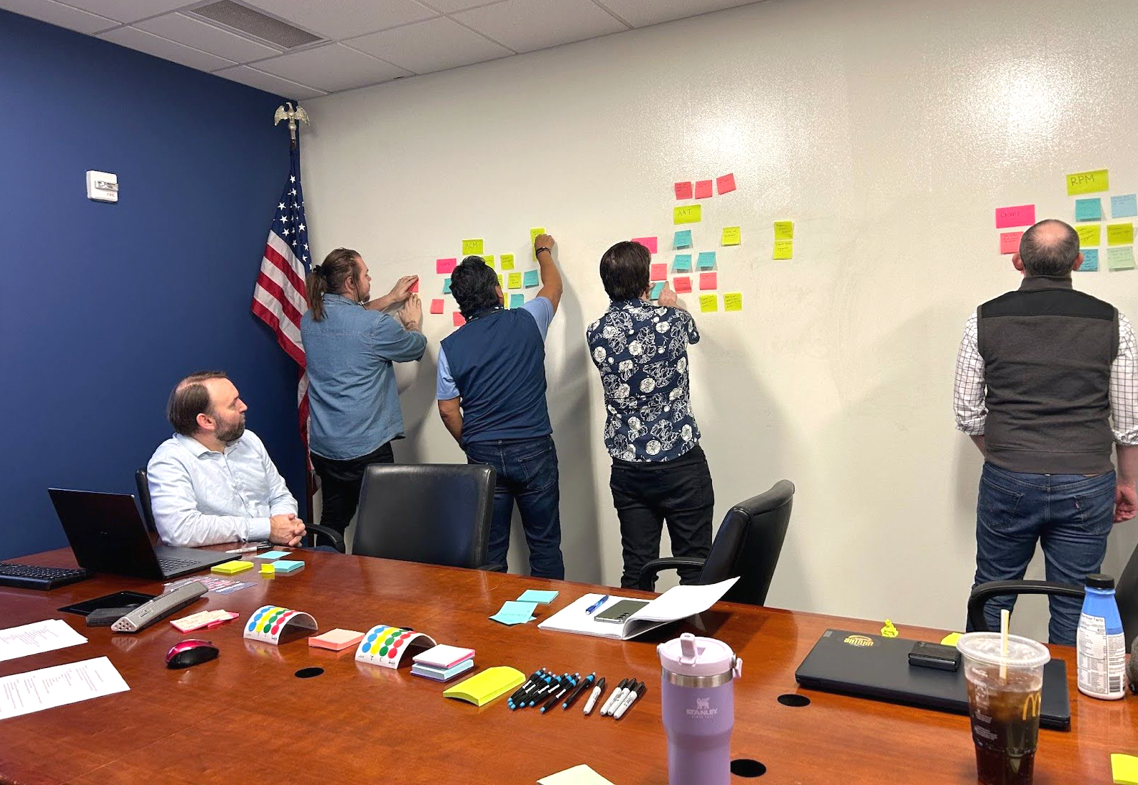 Group of men placing sticky notes on wall