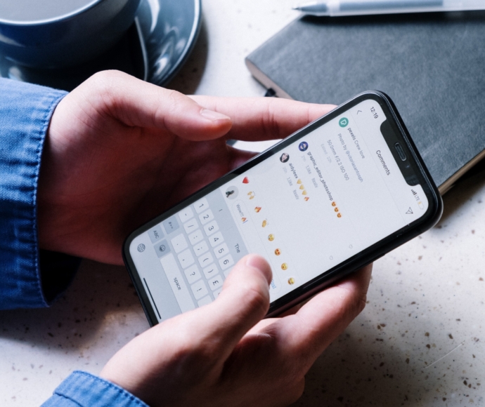 A close up of someone typing a comment on an Instagram post on their iPhone