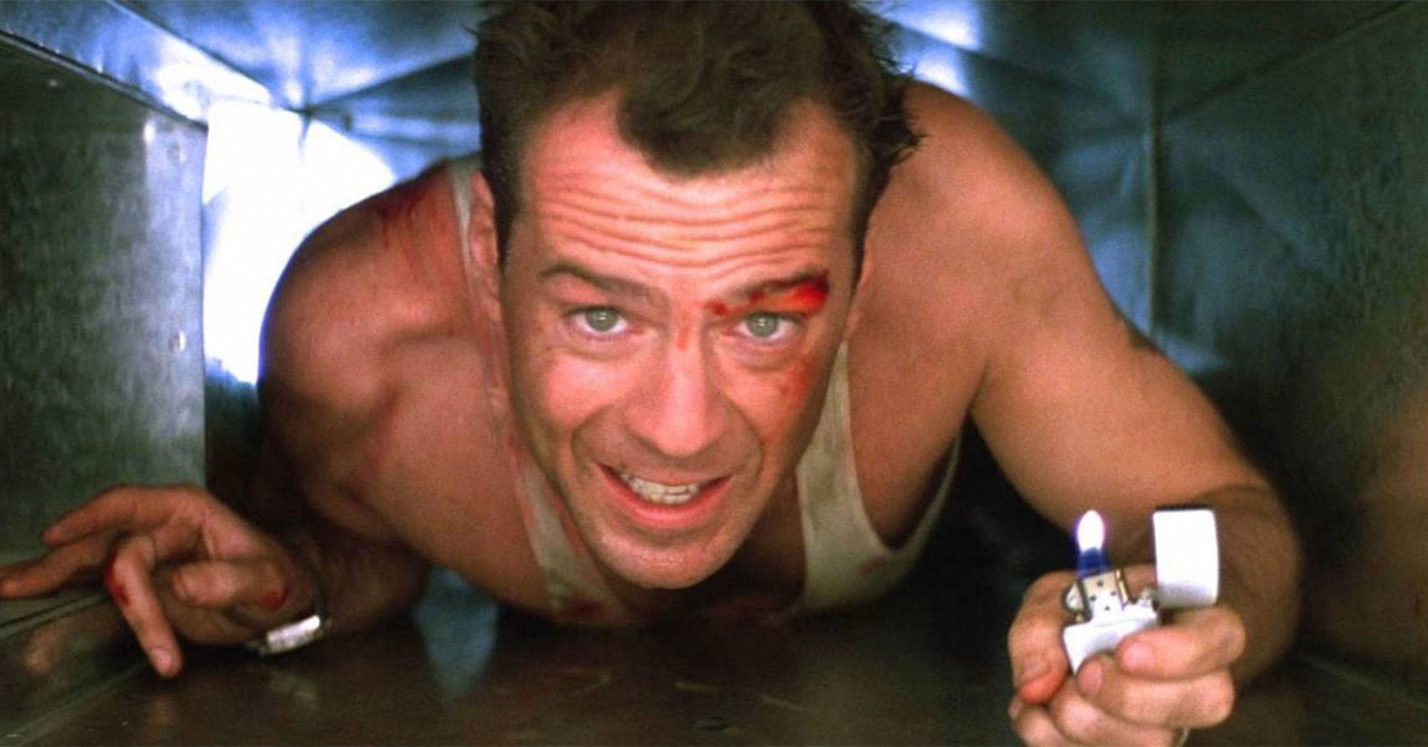 Bruce Willis crawling through an air duct with a lighter from the movie Die Hard.
