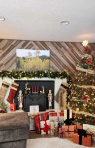 Christmas tree near decorated fireplace