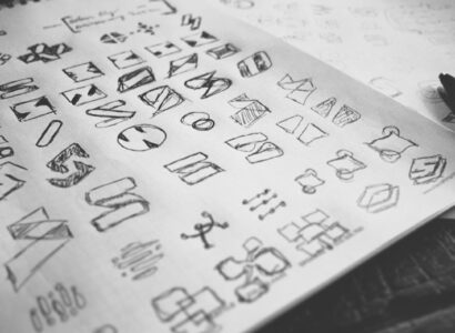 Sketch pad with a grid of hand drawn logo ideas.