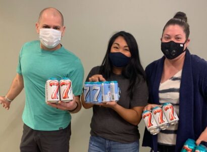 Brian Forth, Angie Carson and Michelle Harrison holding cans of 7 Seas Brewery cans of beer.