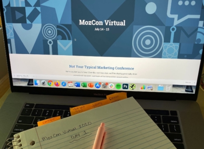 MozCon Virtual 2020 marketing conference website on a laptop screen with a note pad that has day 1 written on it.