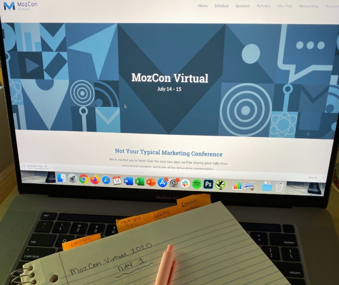 MozCon Virtual 2020 marketing conference website on a laptop screen with a note pad that has day 1 written on it.