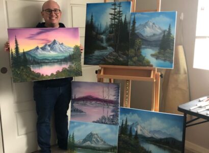 Daniel showing off five of his paintings inspired by Bob Ross