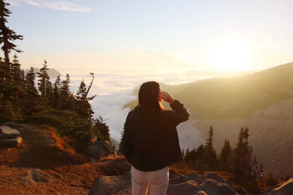 Natalie gazing at hilltops covered by clouds while hiking at Mt. Rainier