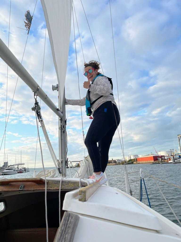 Meredith giving a thumbs up and smiling while on a sailboat