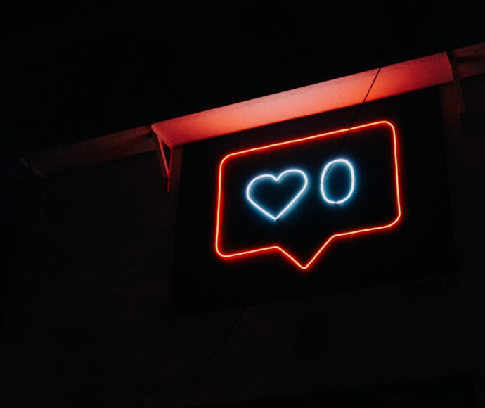Neon sign with a heart and a zero in a speech bubble.