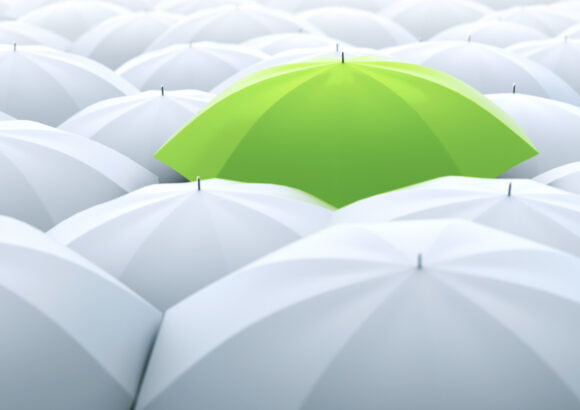 Lime green umbrella among many white umbrellas.