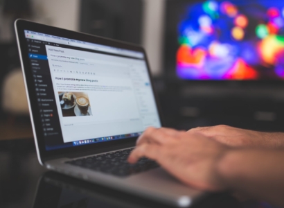 Person writing a blog post on a laptop.